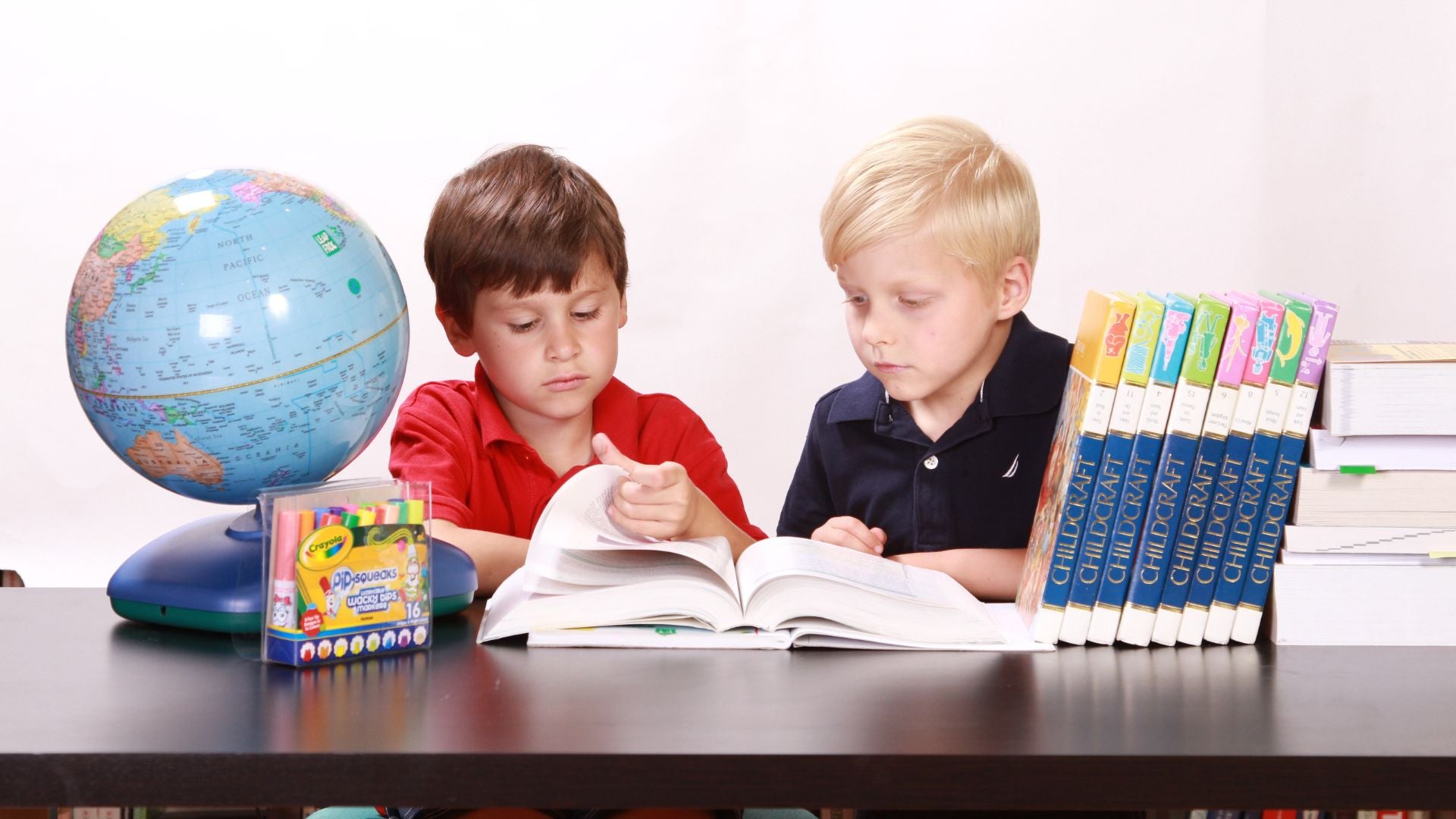 Two young children reading books—exploring early signs of dyslexia symptoms.